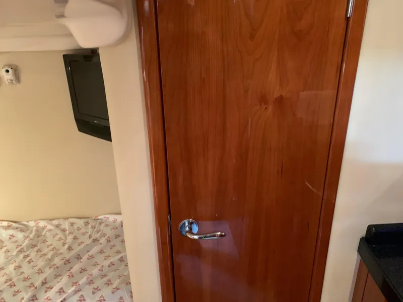 Slide: The Image of Interior of 2009 Regal 4460 yacht with wooden door and bed. - 43