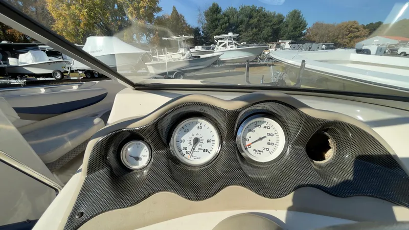 Slide: The Image of 2003 Glastron GX 180 Ski & Fish dashboard with gauges, parked among other boats. - 25