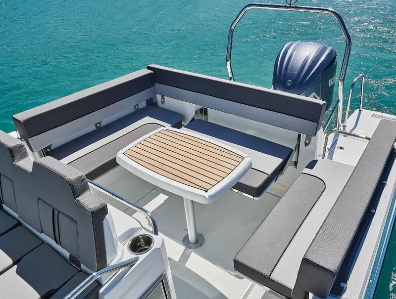 Slide: The Image of 2023 Jeanneau Leader 7.5CC S3 boat with spacious seating and table on clear blue water. - 4