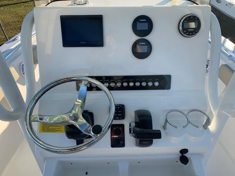 Slide: The Image of 2024 Key West 219 FS boat dashboard with steering wheel, gauges, and controls. - 13