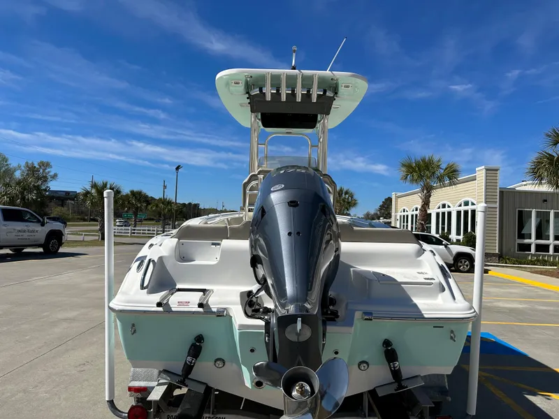 Slide: The Image of 2024 Key West 219 FS boat with outboard motor, docked under clear blue sky. - 3