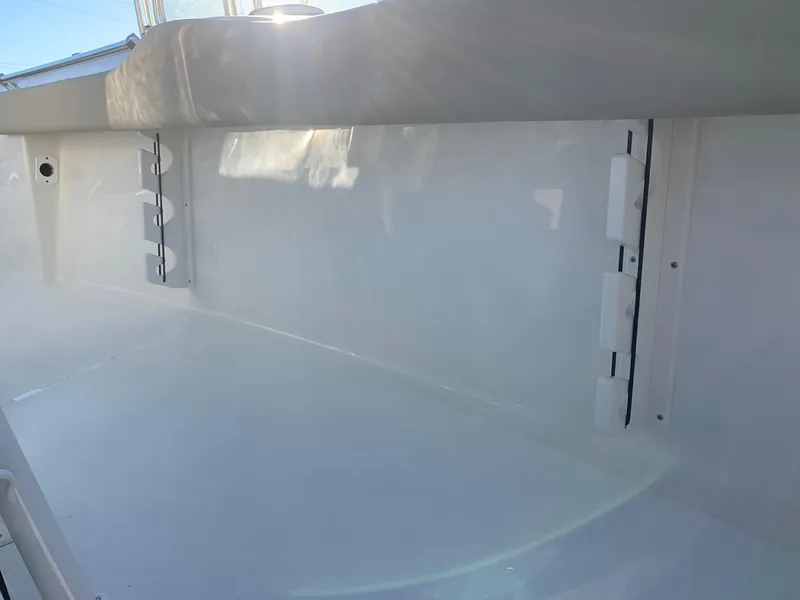 Slide: The Image of 2024 Key West 219 FS boat interior with white seating and storage compartments. - 8