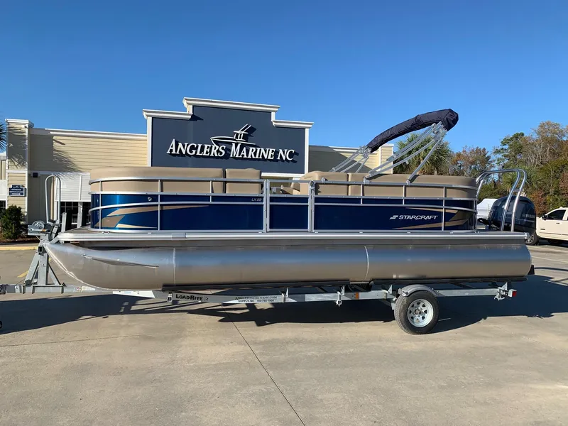 Slide: The Image of 2024 Starcraft LX22 R pontoon boat on trailer at Anglers Marine NC dealership. - 0