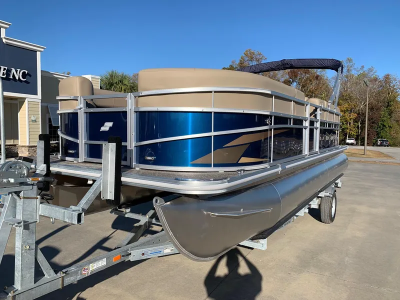 Slide: The Image of 2024 Starcraft LX22 R pontoon boat on a trailer, blue and beige color scheme. - 1