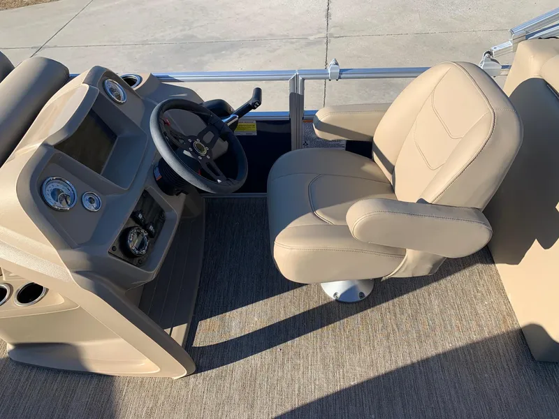 Slide: The Image of 2024 Starcraft LX22 R boat helm with beige captain's chair and dashboard. - 11