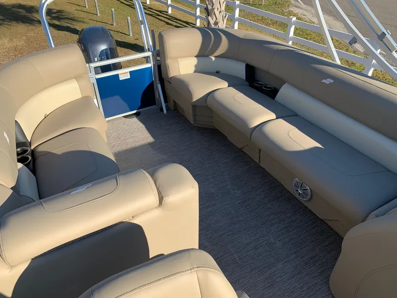 Slide: The Image of 2024 Starcraft LX22 R pontoon boat with spacious beige seating. - 9