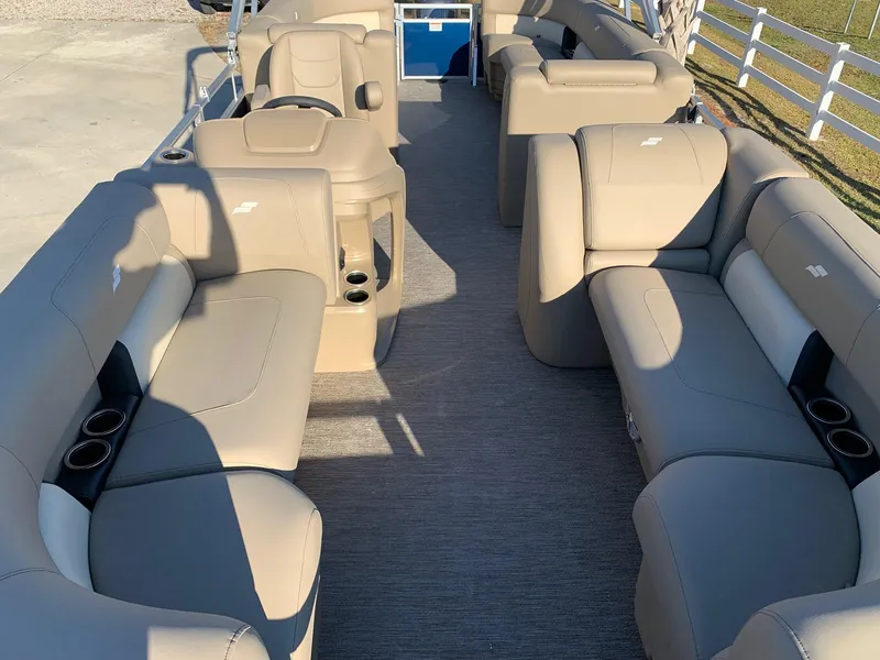 Slide: The Image of 2024 Starcraft LX22 R pontoon boat interior with beige seating and cup holders. - 14