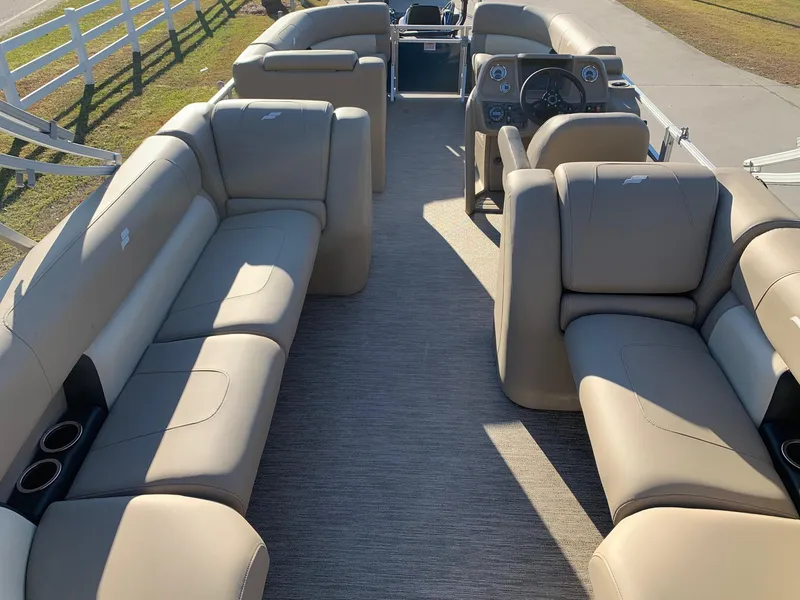 Slide: The Image of 2024 Starcraft LX22 R pontoon boat interior with beige seating and steering console. - 3
