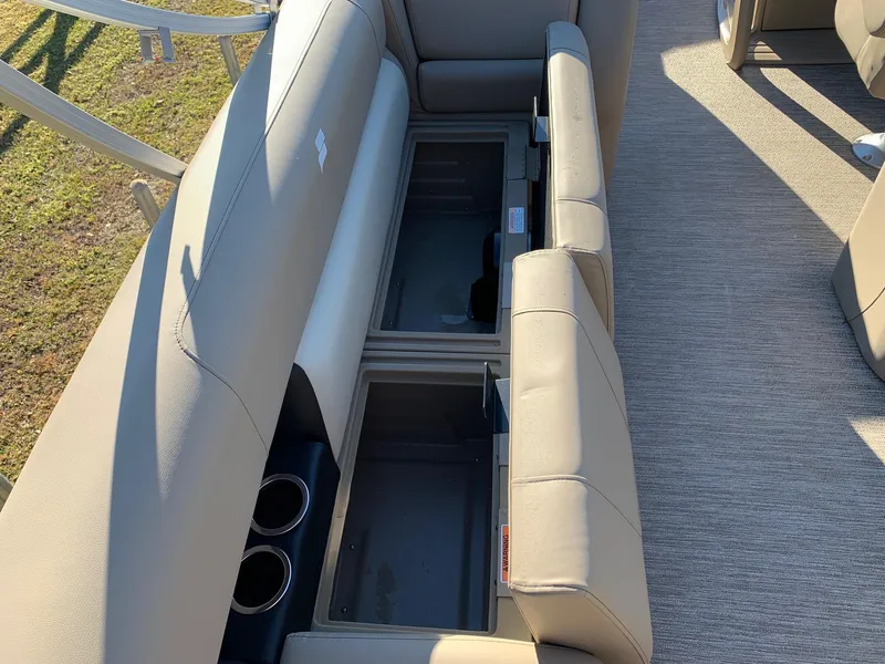 Slide: The Image of 2024 Starcraft LX22 R boat interior with open storage compartments and cup holders. - 8