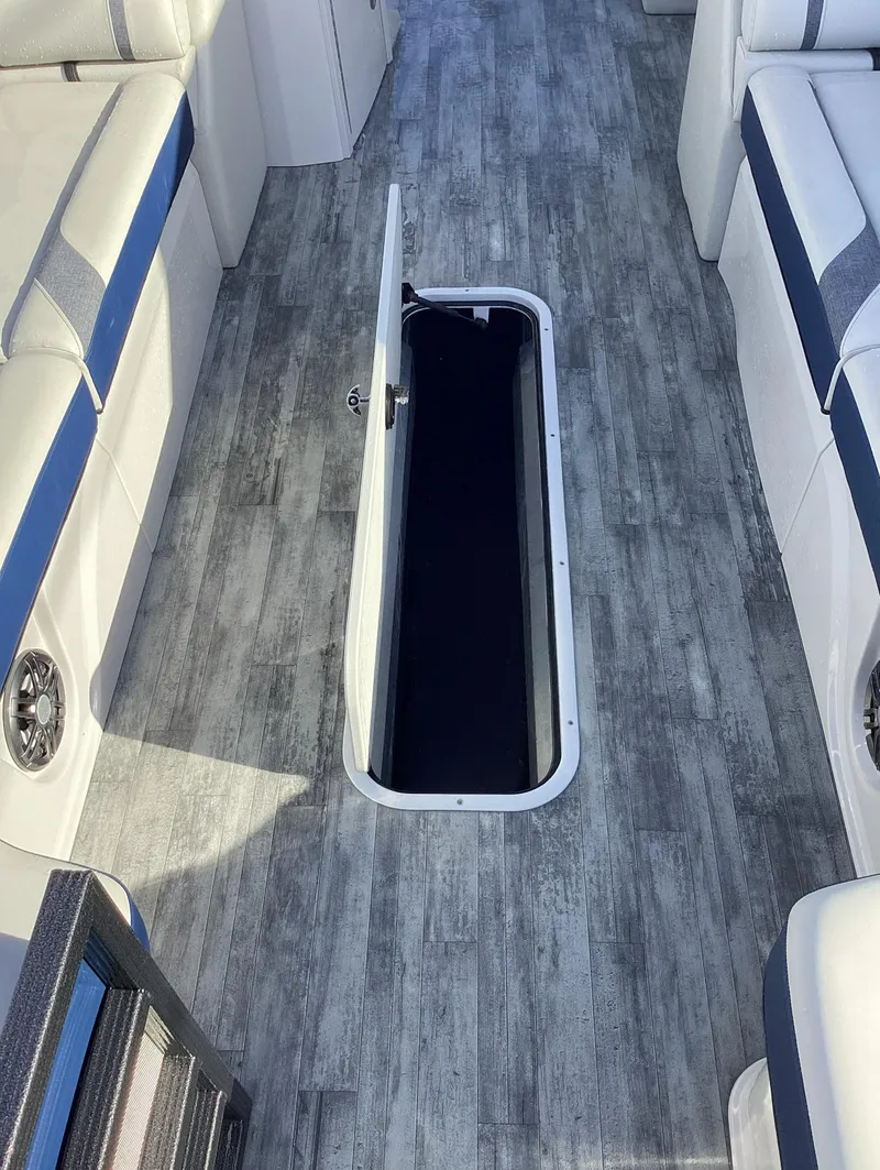 Slide: The Image of 2022 Crest CARIBBEAN LX 250 L boat interior with open storage compartment. - 17