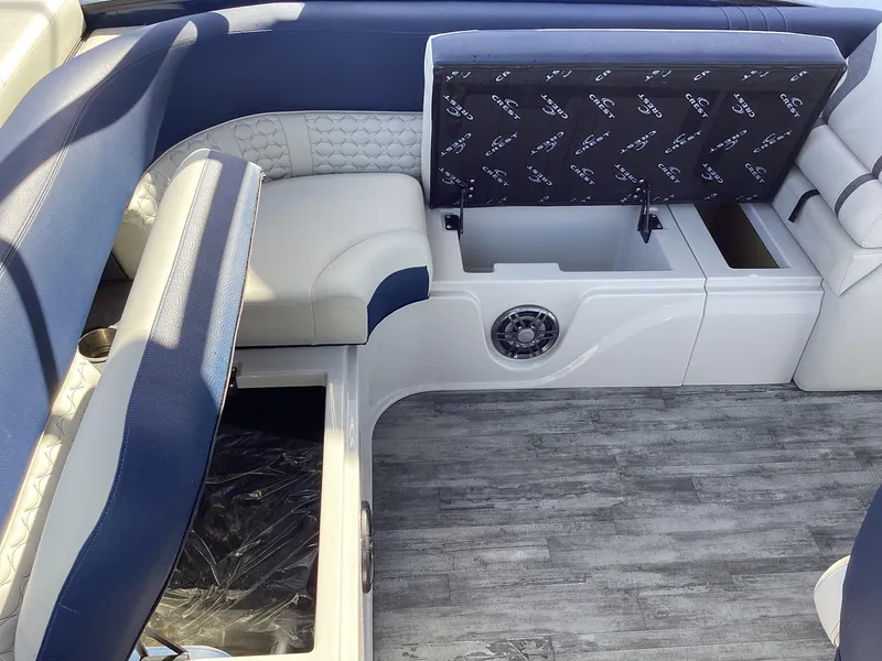 Slide: The Image of 2022 Crest CARIBBEAN LX 250 L boat interior with blue and white seating and storage compartments. - 22