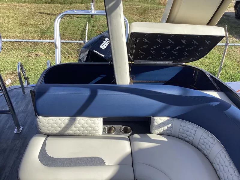 Slide: The Image of 2022 Crest CARIBBEAN LX 250 L boat interior with cushioned seating and storage compartment. - 33