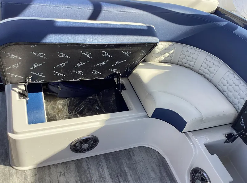 Slide: The Image of 2022 Crest CARIBBEAN LX 250 L boat interior with open storage compartment and cushioned seating. - 34