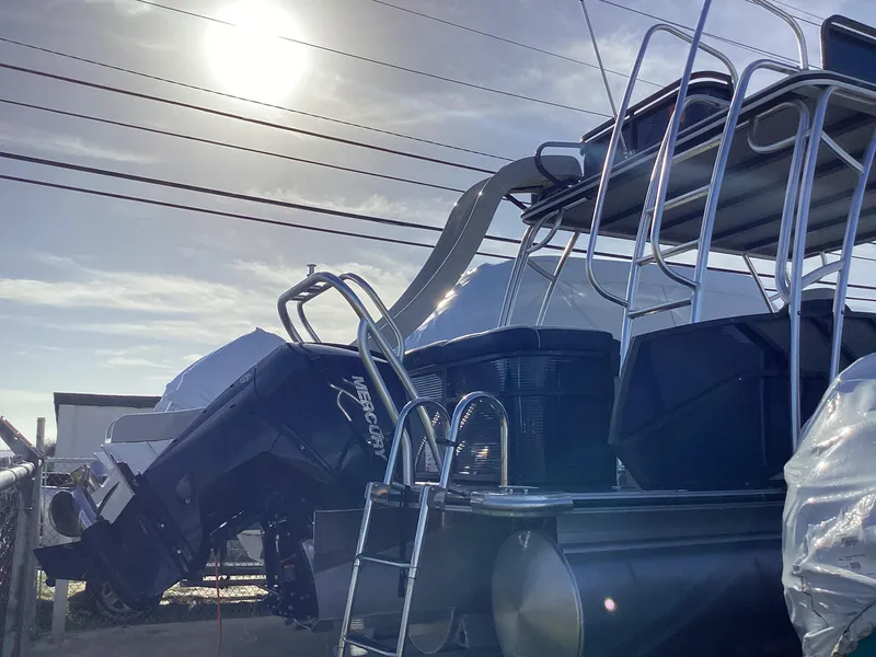 Slide: The Image of 2022 Crest CARIBBEAN LX 250 L pontoon boat with outboard motor in a marina. - 6