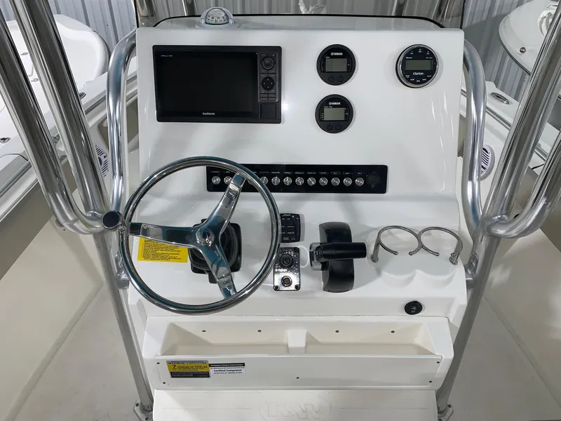 Slide: The Image of 2024 Key West 219 FS boat console with steering wheel, gauges, and electronics. - 2
