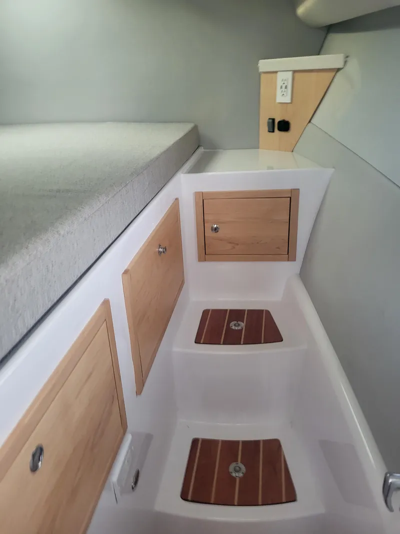 Slide: The Image of 2024 ArrowCat 320 interior cabin with wooden storage compartments and steps. - 7