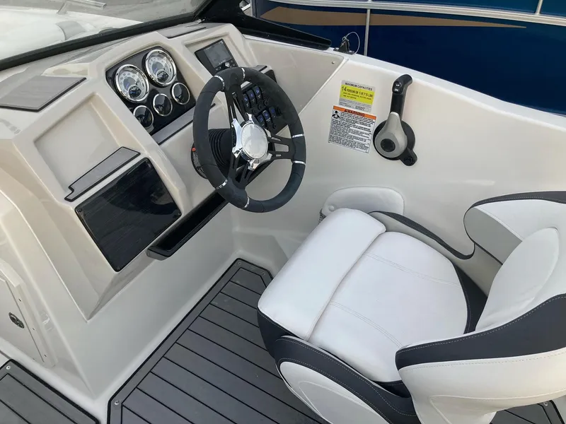 Slide: The Image of 2024 Starcraft SVX 210 boat cockpit with steering wheel and captain's chair. - 12