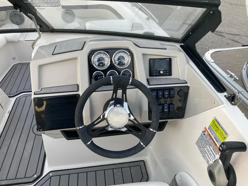 Slide: The Image of 2024 Starcraft SVX 210 boat dashboard with steering wheel and control panel. - 13