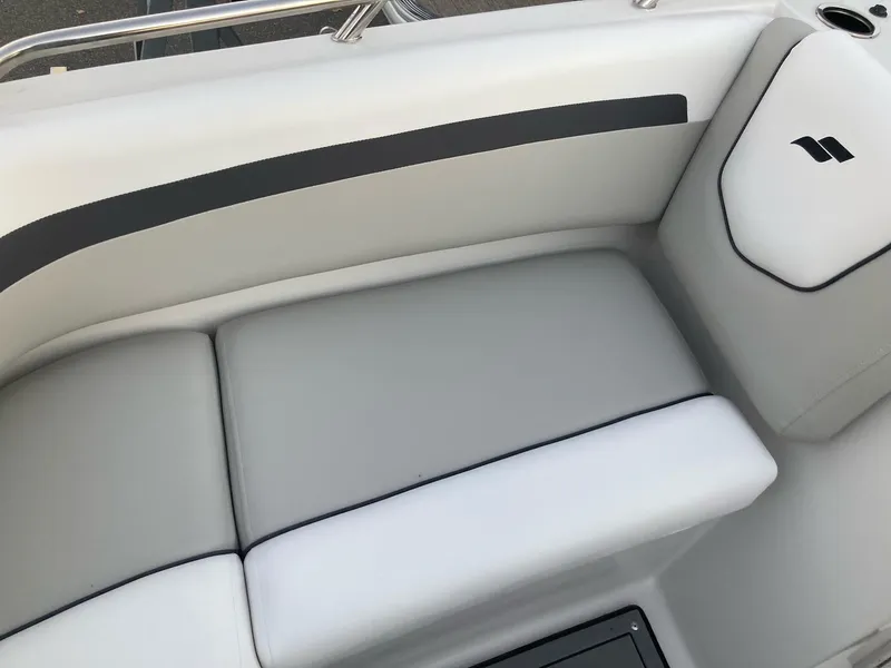 Slide: The Image of 2024 Starcraft SVX 210 boat interior with cushioned seating and sleek design. - 16