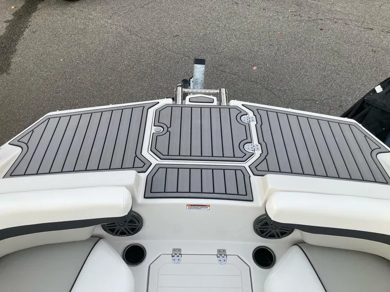 Slide: The Image of 2024 Starcraft SVX 210 boat deck with gray and white seating and storage compartments. - 18