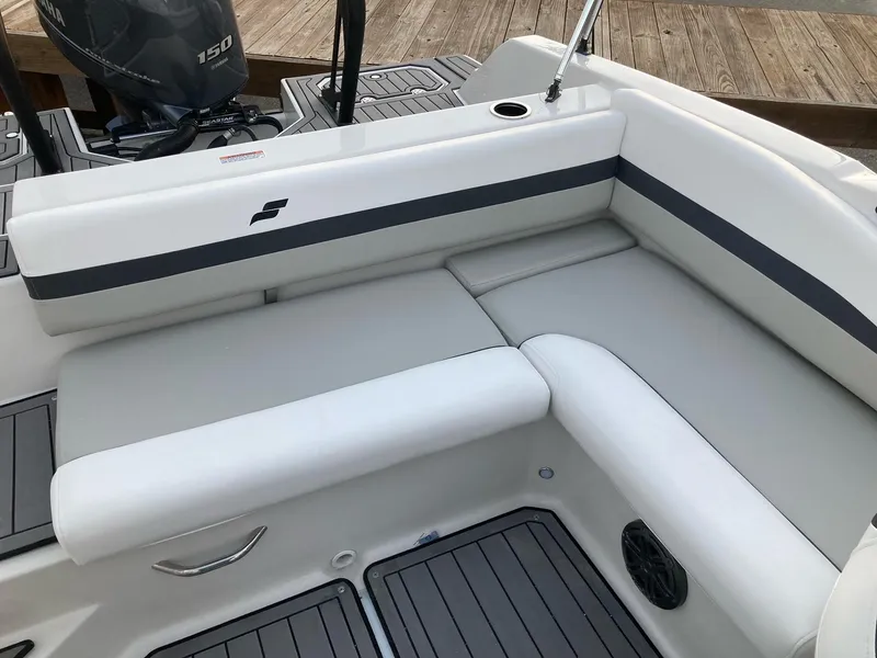 Slide: The Image of 2024 Starcraft SVX 210 boat interior with cushioned seating and outboard motor. - 7