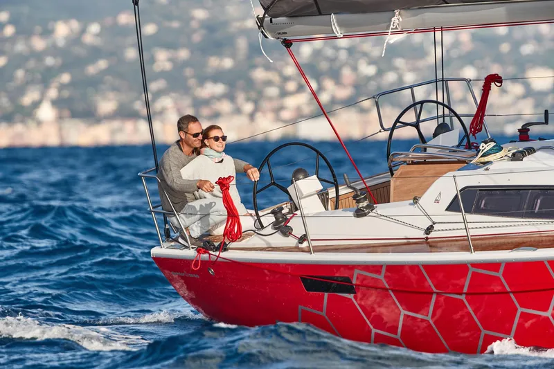 Slide: The Image of Couple sailing on a 2025 Dehler 38 SQ yacht in open waters. - 2