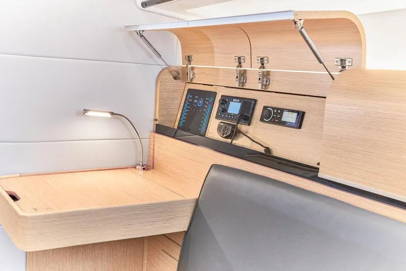 Slide: The Image of Dehler 38 SQ 2025 yacht interior navigation station with modern control panels and wooden finish. - 22
