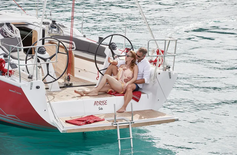 Slide: The Image of Couple relaxing on a 2025 Dehler 38 SQ sailboat in clear blue water. - 3