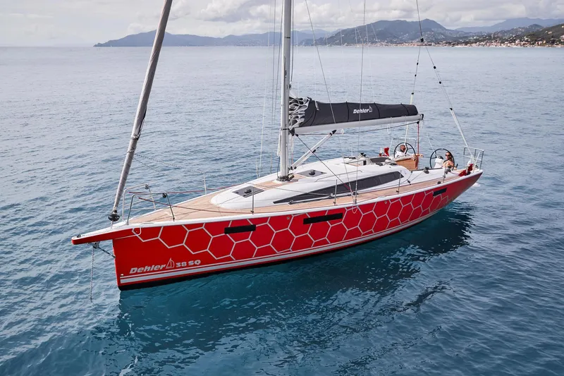 Slide: The Image of 2025 Dehler 38 SQ sailboat on calm waters with scenic coastline backdrop. - 7