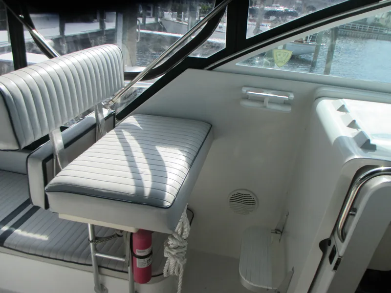 Slide: The Image of Mainship 30 PILOT 2000 boat interior with cushioned seating and window view. - 10
