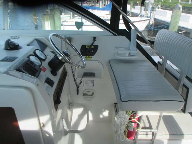 Slide: The Image of Cockpit of a 2000 Mainship 30 PILOT boat with steering wheel and control panel. - 11
