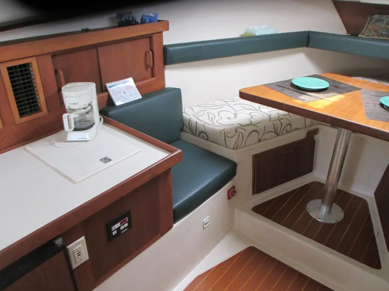 Slide: The Image of Interior of a 2000 Mainship 30 PILOT boat with seating and dining area. - 16