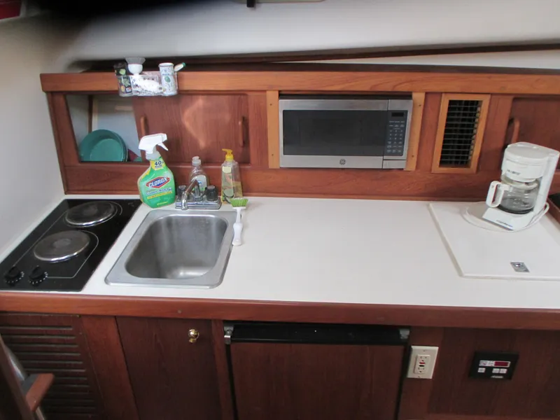 Slide: The Image of Compact kitchen area in a 2000 Mainship 30 PILOT boat with sink, stove, microwave, and coffee maker. - 17