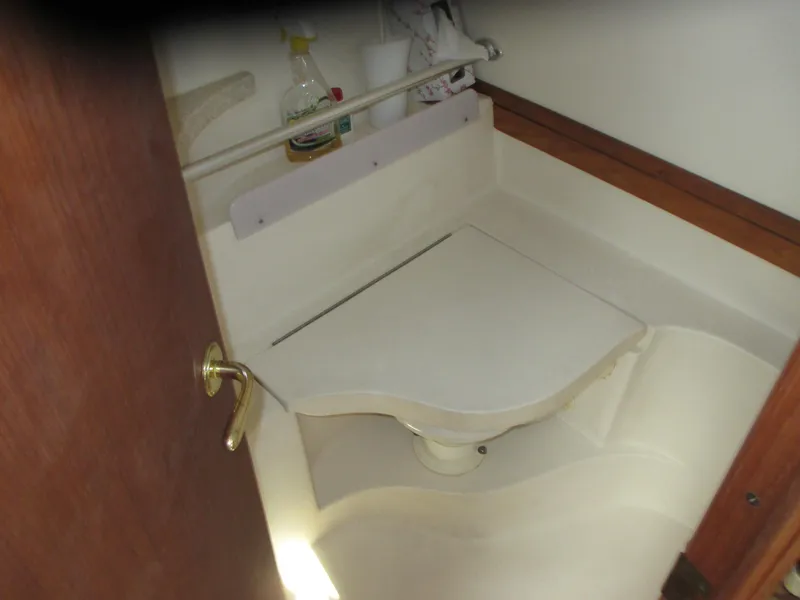 Slide: The Image of 2000 Mainship 30 PILOT boat bathroom with compact toilet and storage shelf. - 20