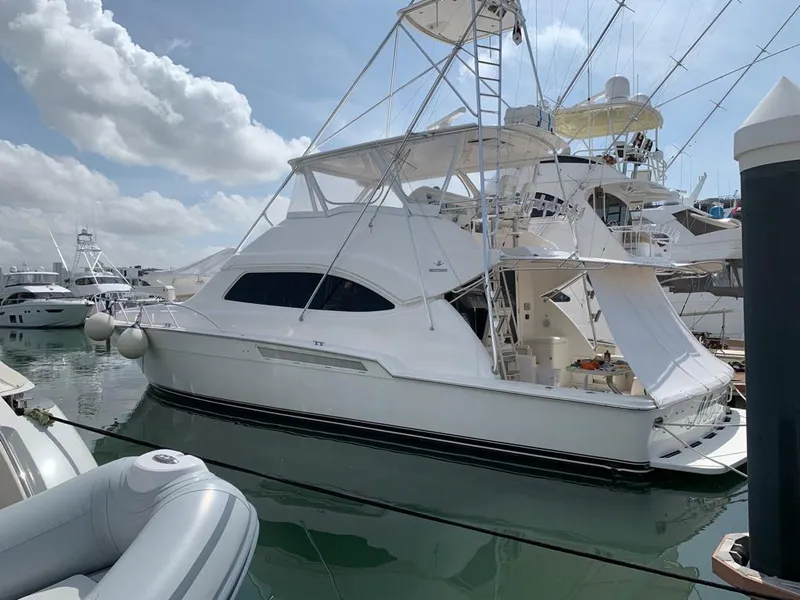 Slide: The Image of 2005 Bertram 570 yacht docked at marina under blue sky. - 1