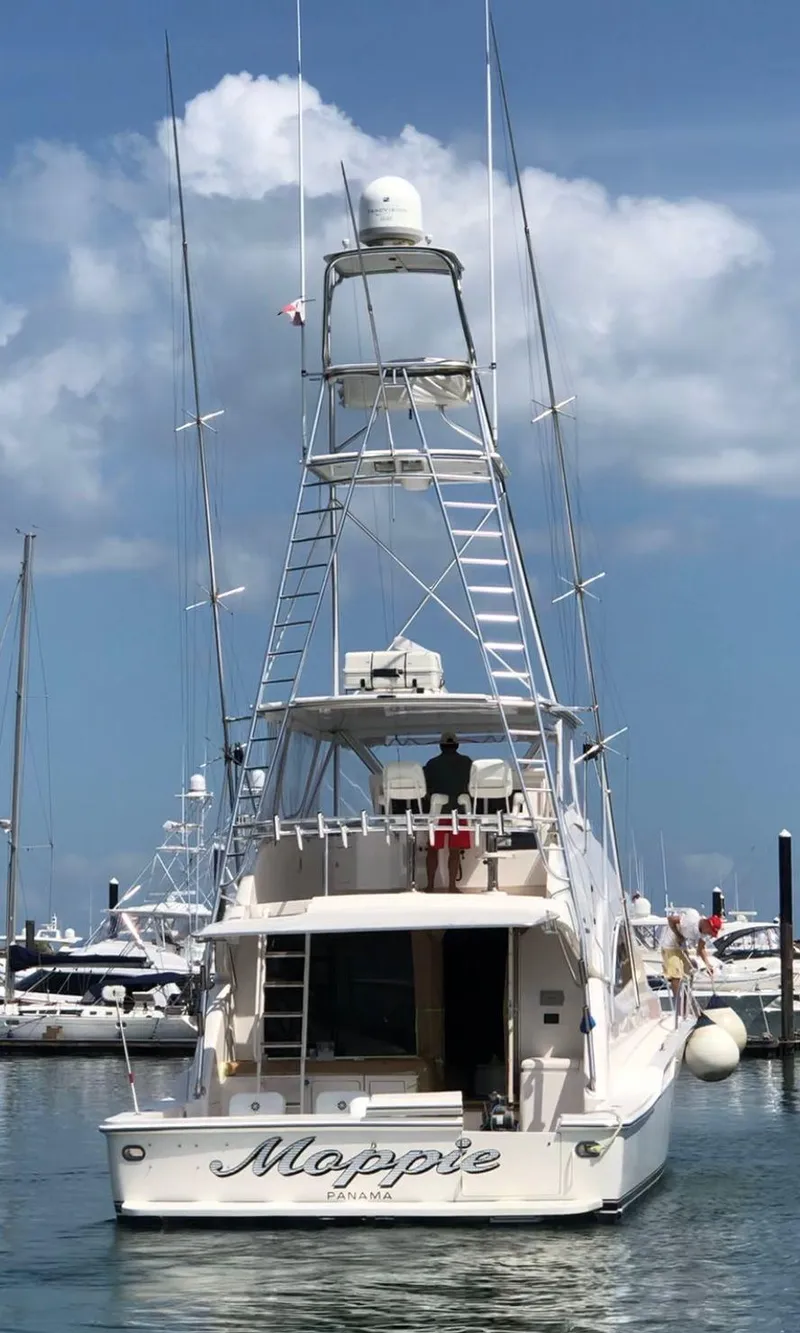 Slide: The Image of 2005 Bertram 570 yacht docked at marina under blue sky. - 2