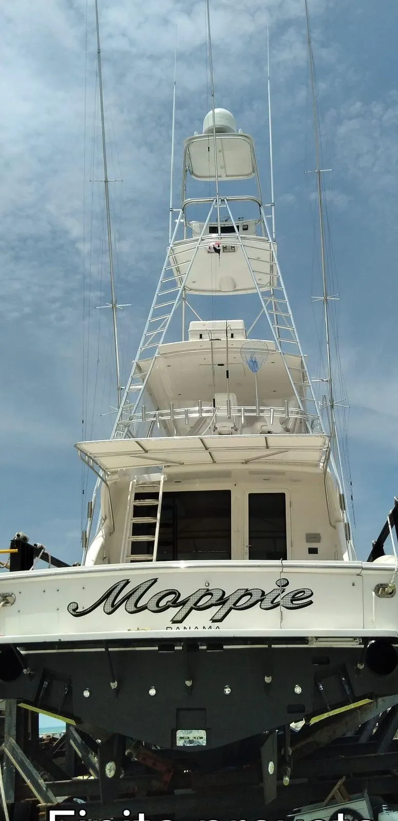 Slide: The Image of Alt text: 2005 Bertram 570 yacht named Moppie with a tall tower, docked under a blue sky. - 3