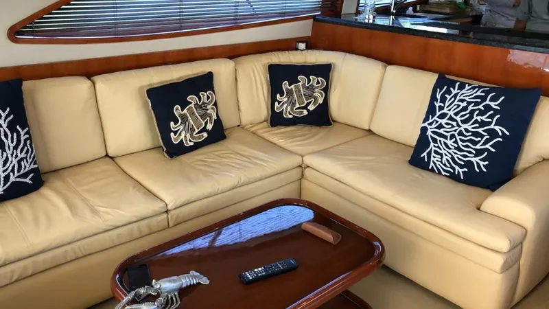 Slide: The Image of Luxurious beige leather sofa in 2005 Bertram 570 yacht with nautical-themed pillows. - 5