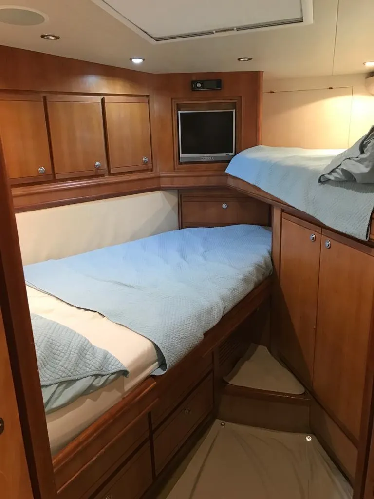 Slide: The Image of 2005 Bertram 570 cabin with wooden interior and bunk beds. - 9