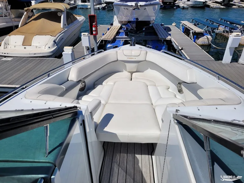 Slide: The Image of 2014 Formula 290 BR boat with white leather seating at a marina. - 10