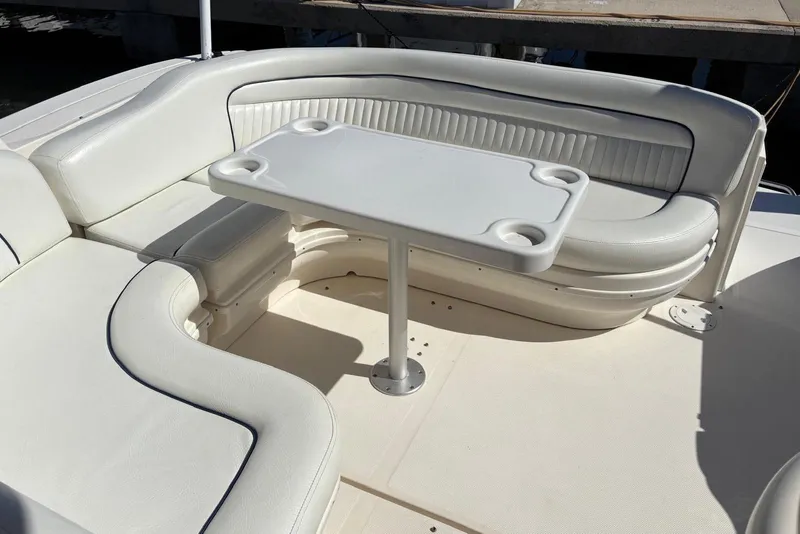Slide: The Image of 2005 Sea Ray 340 Sundancer boat seating area with white upholstery and table. - 61