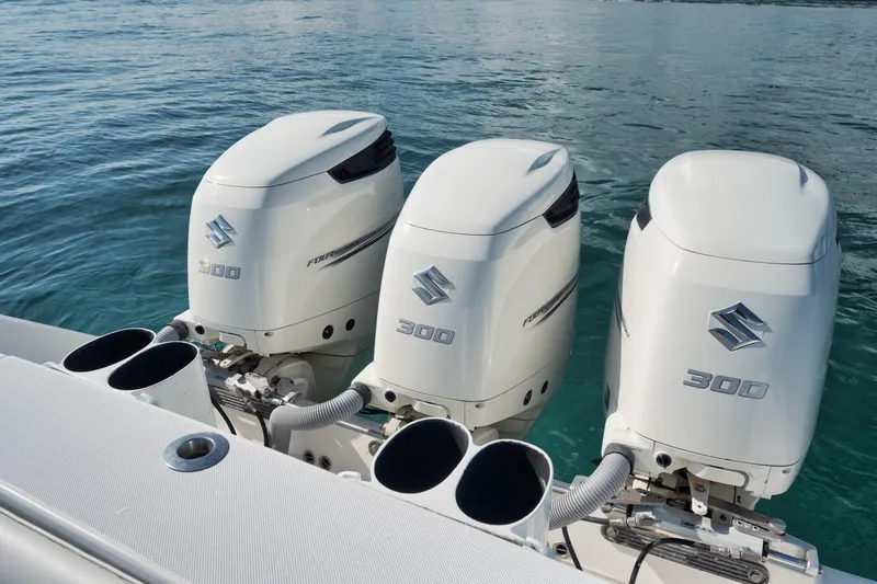 Slide: The Image of Triple Suzuki 300 outboard engines on a 2010 Jupiter 38 CC boat in calm waters. - 21
