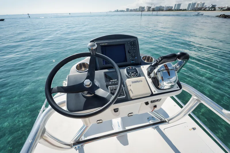 Slide: The Image of Helm of 2010 Jupiter 38 CC boat with steering wheel and controls on clear water. - 8