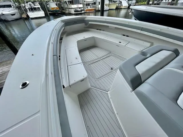 Slide: The Image of 2020 Regulator 41 boat with spacious seating and storage, docked at a marina. - 13