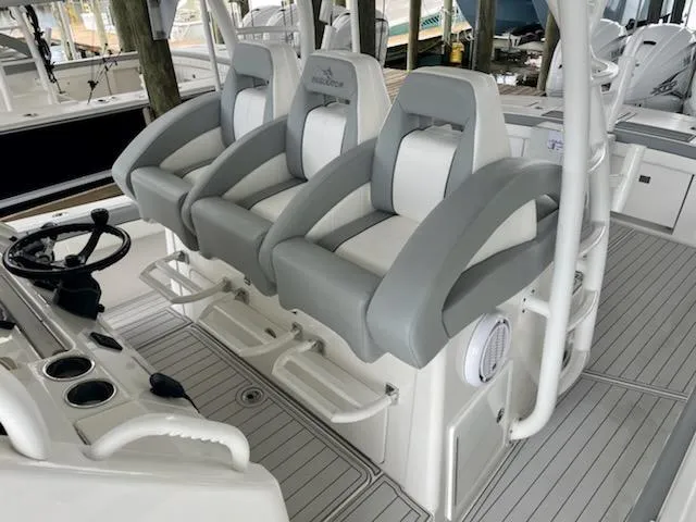 Slide: The Image of 2020 Regulator 41 boat with three cushioned helm seats and steering console. - 17