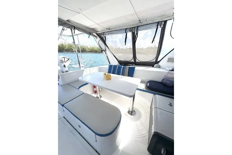 Slide: The Image of 1998 Leopard Catamaran interior with seating area, table, and scenic water view. - 14