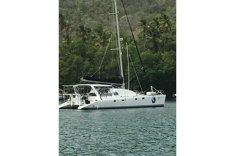 Slide: The Image of 1998 Leopard Catamaran anchored near lush, tropical shoreline. - 2
