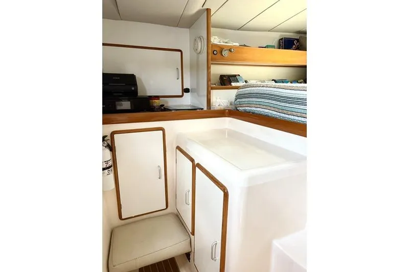 Slide: The Image of Interior of a 1998 Leopard Catamaran featuring a compact cabin with storage and seating. - 22