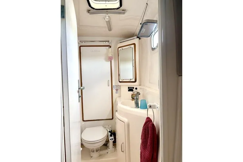 Slide: The Image of Bathroom interior of a 1998 Leopard Catamaran, featuring a toilet, sink, and mirror. - 25