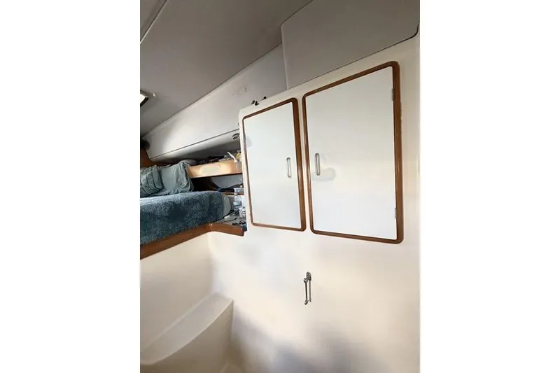 Slide: The Image of Interior of a 1998 Leopard Catamaran showing storage cabinets and a cozy sleeping area. - 43